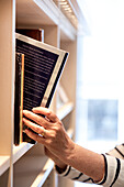 Hand taking book from shelf