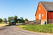 Tractor on dirt road near barn
