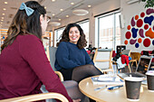 Female friends talking in library