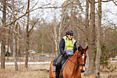 Smiling woman horseback riding