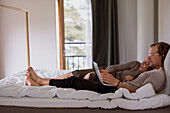 Couple on bed looking at laptop