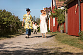 Toddler boy walking with mother and grandmother