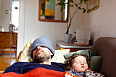 Father and daughter sleeping on sofa