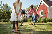 Family playing croquet in garden