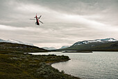 Helicopter over lake in mountains