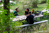 Frau und Männer auf einer Picknick-Bank