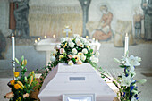 Flowers lying on white coffin