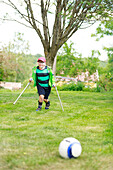 Junge spielt Fußball im Garten