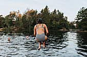 Rückansicht einer Frau, die ins Wasser springt