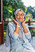Smiling woman listening music via headphones