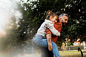 Father giving daughter piggyback ride