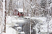 Winter landscape with wooden house at river