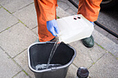 Pouring detergent into bucket