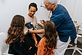 Doctor checking womans blood pressure