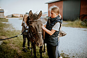Girls preparing horse for ride