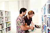 Men choosing books in library
