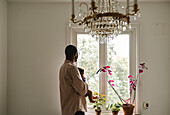 Father with baby looking through window