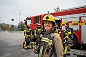 Female firefighter in front of fire engine