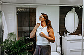 Woman drying face in bathroom