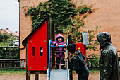 Toddler girl standing on top of slide