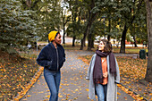 Zwei junge Frauen gehen im Park spazieren