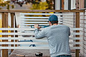 Carpenter using spirit level on patio railing