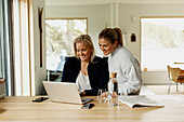 Two women working with laptop at home