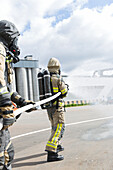Firefighters holding fire hose