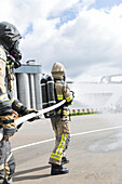 Feuerwehrleute halten Feuerwehrschlauch