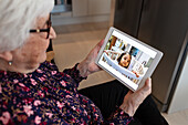 Hände halten ein digitales Tablet mit einem Bild eines kleinen Mädchens