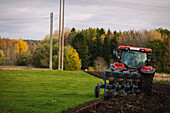 Traktor pflügt Feld im Herbst