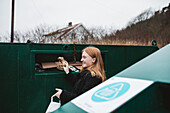 Woman putting rubbish into recycling bin