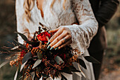 Mid section of bride holding wedding bouquet