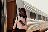 Junge Frau telefoniert auf dem Bahnsteig