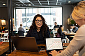 Weibliche Coworker arbeiten zusammen in einem Café
