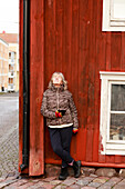 Senior woman standing against wooden wall