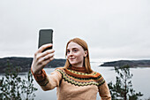 Lächelnde junge Frau macht Selfie