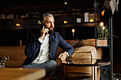 Businessman talking via cell phone in cafe