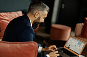 Businessman using cell phone in cafe