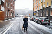 Frau mit Hund beim Spaziergang auf der Winterstraße