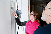 Female plumber checking boiler