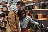 Couple looking at flower pots in shop