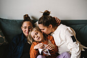 Women with girl on sofa