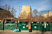 Woman putting rubbish into recycling bins