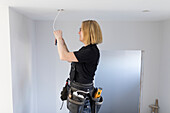 Female electrician renovating house