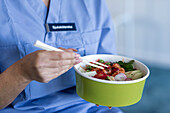 Krankenschwester isst asiatisches Essen zum Mitnehmen