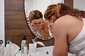 Woman washing her face in bathroom