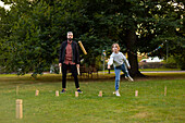 Father and daughter playing molkky game in park