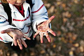 Mädchen zeigt schmutzige Hände