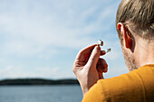 Man taking off hearing aid